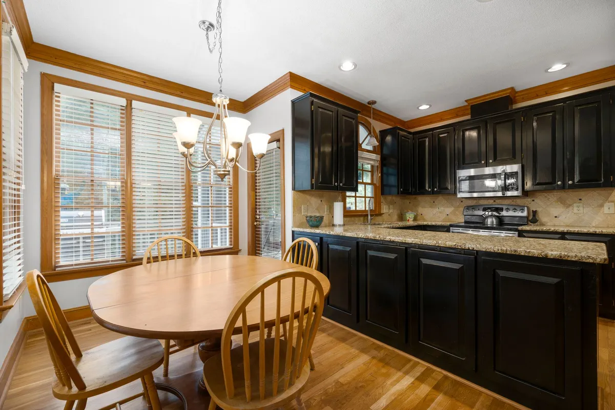 Kitchen with dark espresso cabinets, granite countertops and an adjoining dining area