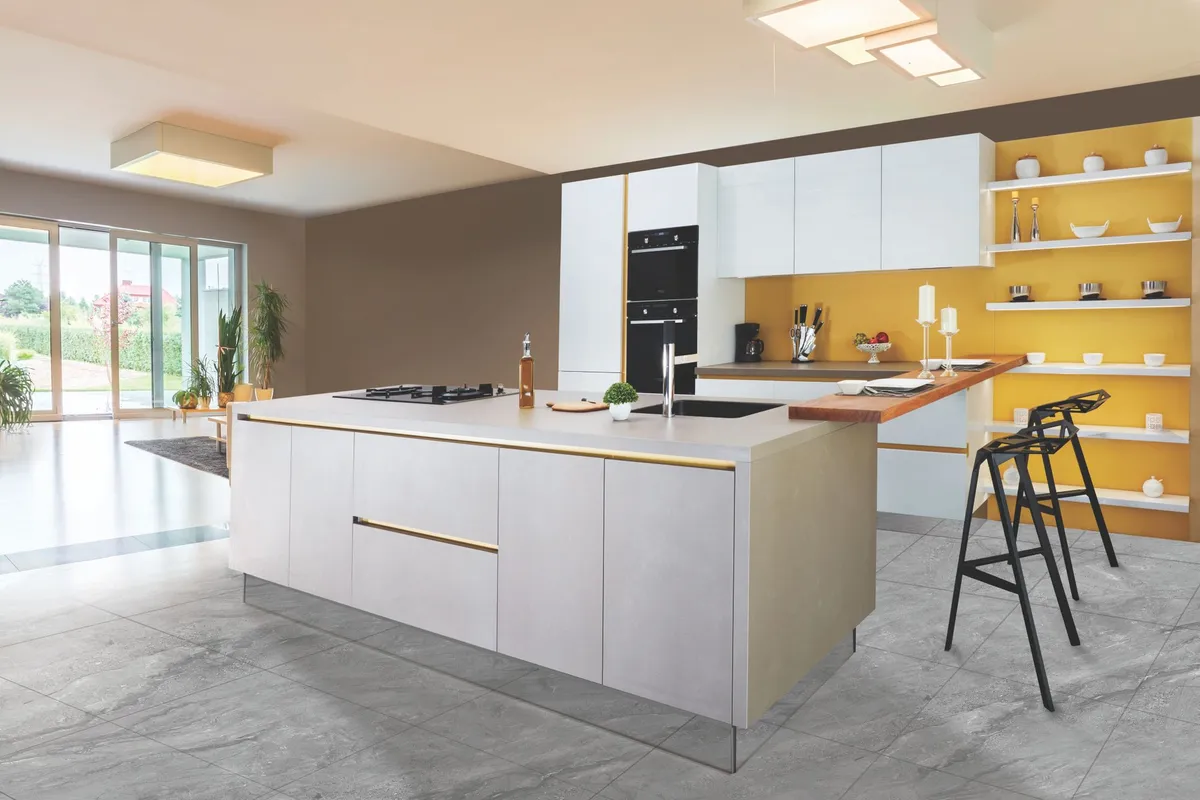 Wide kitchen island with bar stools, white cabinets and yellow open shelving along the back wall